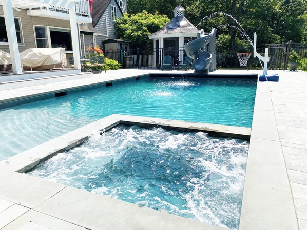 The pool has a heated spa, water jets, a helical slide and a basketball hoop.