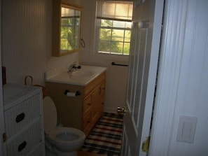 Full Bathroom with laundry, dresser with towels and sheets