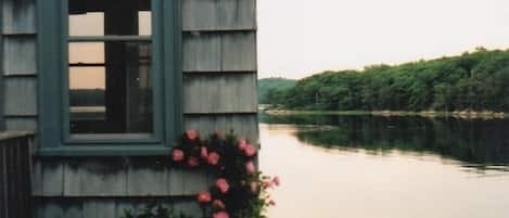 view of sunporch & millpond sunset in June with roses