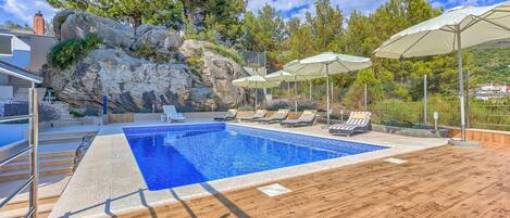 Pool area with loungers and parasols