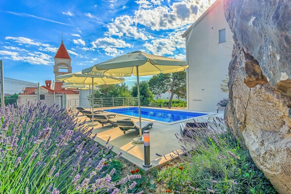 Pool area with loungers and parasols