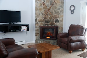 An electric fireplace heater sits in the corner of the sitting area. 