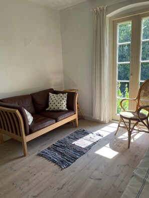 sofa in living area next to the french door and firestove