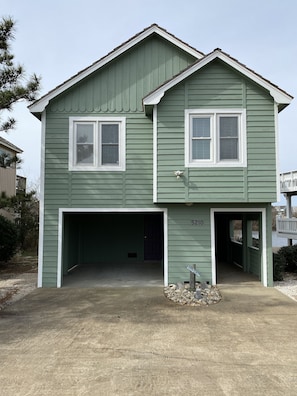 Front of cottage with covered open garage and walkway to entry 