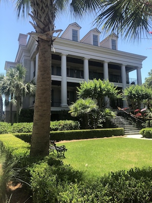 Large front yard with Charleston benches. Beautiful gardens!