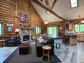 Open living room with Flatscreen tv, gas fireplace, kitchen and dining area