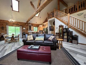 Open living room with Flatscreen tv, gas fireplace, kitchen and dining area