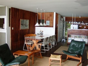 Fireplace seating with dining table and kitchen beyond