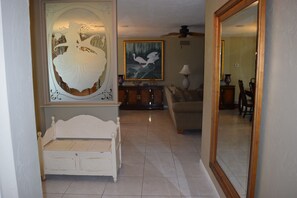 Inviting entry foyer with bench and etched glass mermaid.