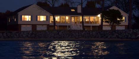 SuperMoon rising behind the house with moon beams on the bay