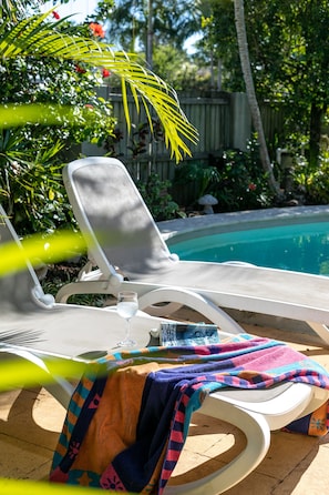 Relax by the topical pool with a good book and glass of wine.