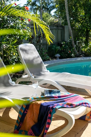 Relax by the topical pool with a good book and glass of wine.