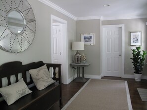 Foyer view, entrance to kitchen on left and door to powder room