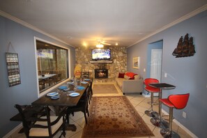 Dining area with fireplace with gas logs, 60" tv, 10' table and queen sofabed.