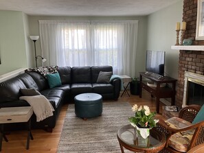 Living room with flat screen tv and brick fireplace 