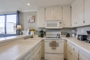 Kitchen with oven, blender, microwave, sink, toaster, coffee pot