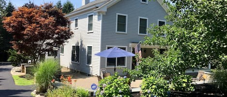 Front of House with large patio and long driveway on the left.