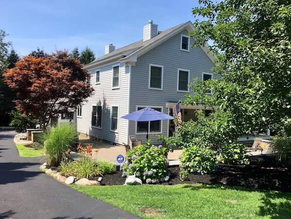 Front of House with large patio and long driveway on the left.