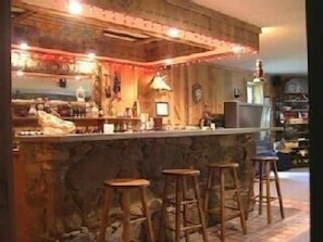 Eighteen foot, stone bar w/ refrigerator. BYOB and make it a night!