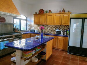 large kitchen with commercial stove and refrigerator, regular fridge also