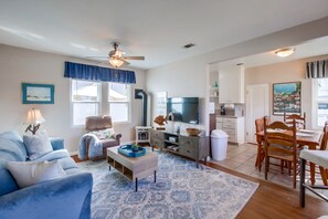 Front door opens to the living room with a queen sofa bed, Roku TV, ceiling fan, and overhead lighting