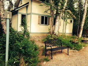 Side view of Cabin with pathway bench and lampposts.
