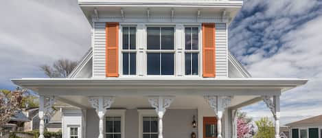 Front view with welcoming front porch and widow's walk on third level