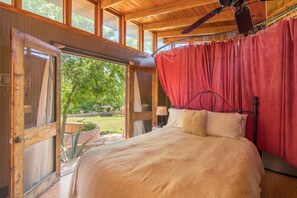Inviting queen bed with sexy reds throughout the room, and greens right outside!