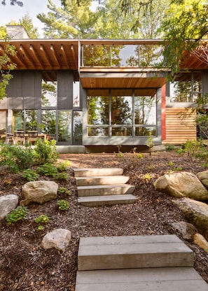 Steps up from the lake lead to this secluded award-winning handcrafted wood home