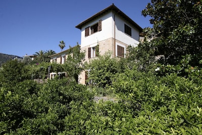 House among orange trees and garden with privileged views of the Sóller Valley.