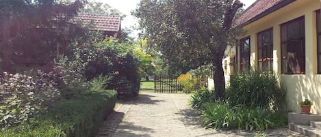 Open the gates and you see the house on right, garden left, and farmyard ahead.