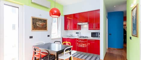 Living room with fully equipped kitchen and dining area.