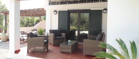 Covered Terrace with sofa & chairs seating & doors to apartment 