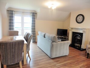 Open plan living and dining room with balcony view of River