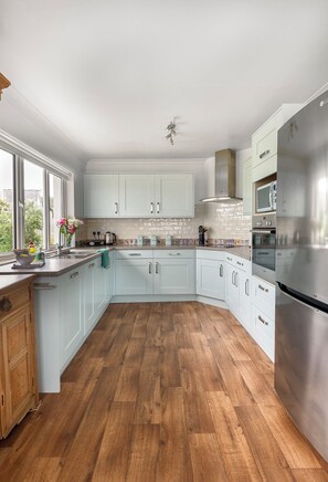 Modern kitchen with fridge freezer, dishwasher, microwave and sea views. 