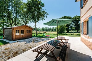 Terrace with the sun shining. Paddling pool and sun loungers.