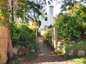 Pathway to the cottage with rustic gate from the private parking area