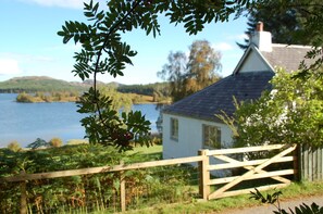 The side view of the Cottage down to the garden and Loch Knockie.