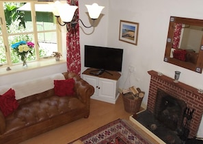 Lounge with Laura Ashley leather sofas and views of the stream and woods.