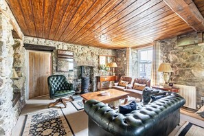 One of the sitting areas in the main reception room - with Chesterfield sofa, two armchairs and a Chesterfield chair.  The antique woodburning stove is decorative - the main woodburning stove is powerful enough to heat the room.  Lovely at Christmas!