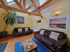 Spacious sitting room with vaulted ceiling and glass sliding door