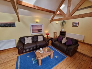 Spacious sitting room with vaulted ceiling and glass sliding door