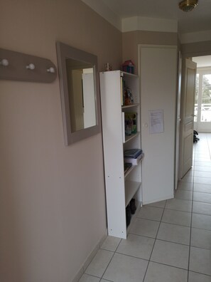 Entrée avec bibliothèque et miroir.