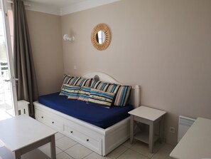 Séjour avec lit-gigogne offrant 2 couchages une fois déplié.