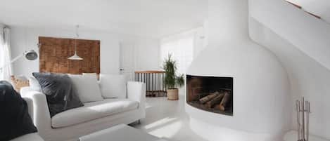 The 50m2 main living with fireplace. Stair to roof terrace