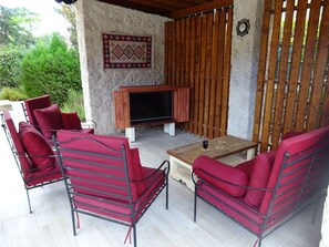 Outdoor shaded lounge area with Smart TV. 
