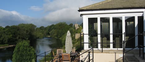 River Tees, estufa e zona exterior de refeição, a partir do terraço jardim.