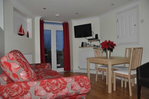 Lounge/diner with double doors out to sunshine deck overlooking bay.