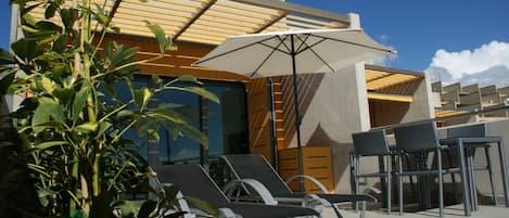 Big terrace with hammocks, umbrella and table for breakfast in front of the sea