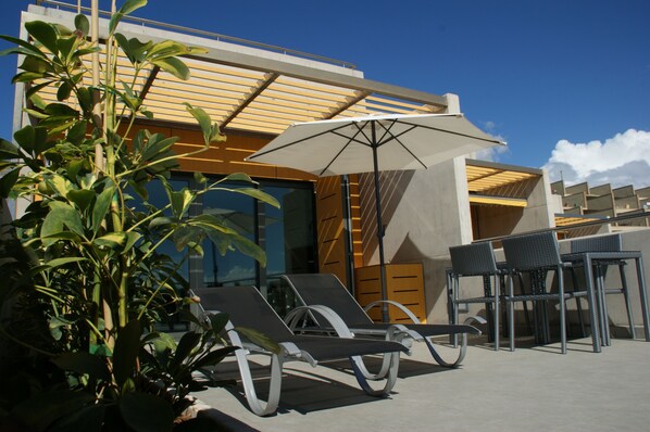 Big terrace with hammocks, umbrella and table for breakfast in front of the sea